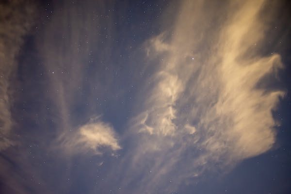 A vast array of stars interspersed with yellow-y clouds against a nighttime sky