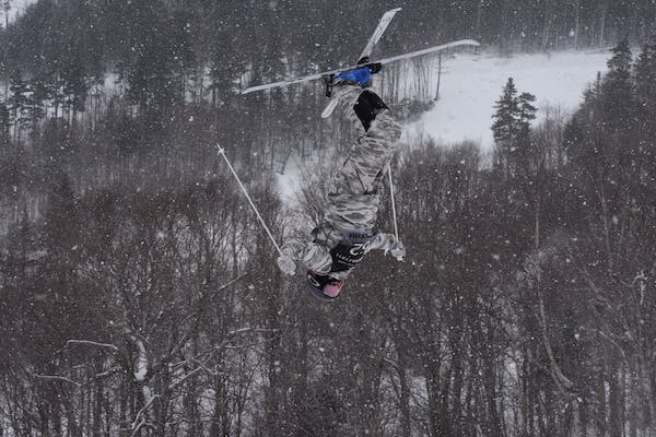Gavin Tobey doing a flip off a ski jump at Waterville Valley, he is depicted upside-down here